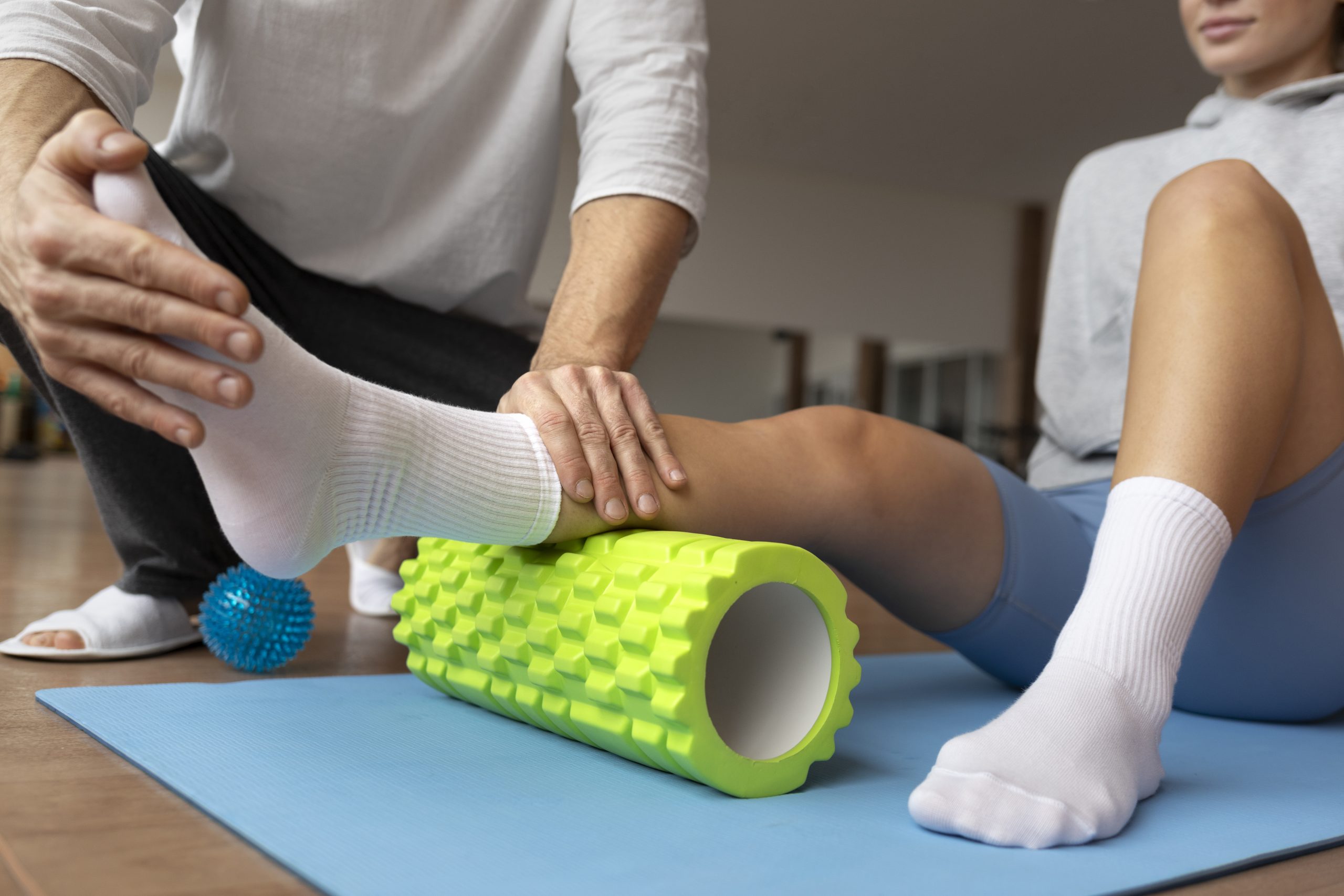 paciente haciendo rehabilitacion fisica ayudado por terapeutas scaled